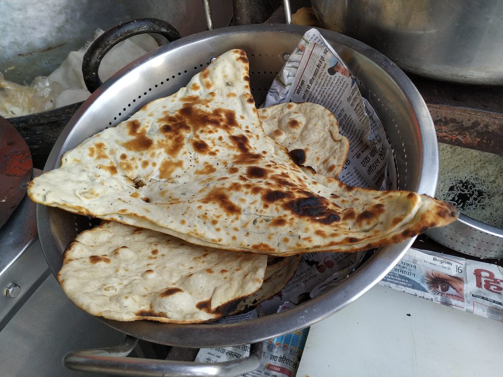 Fresh naan bread baked in a traditional clay tandoor oven