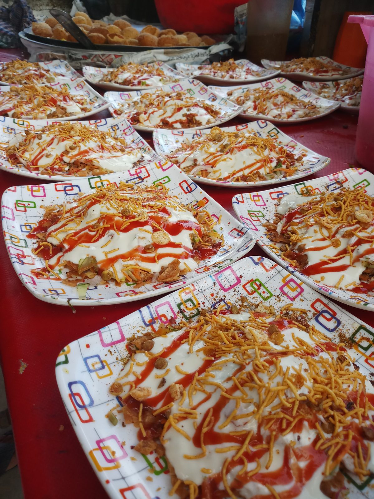 Papri chaat topped with yogurt, chutneys and sev