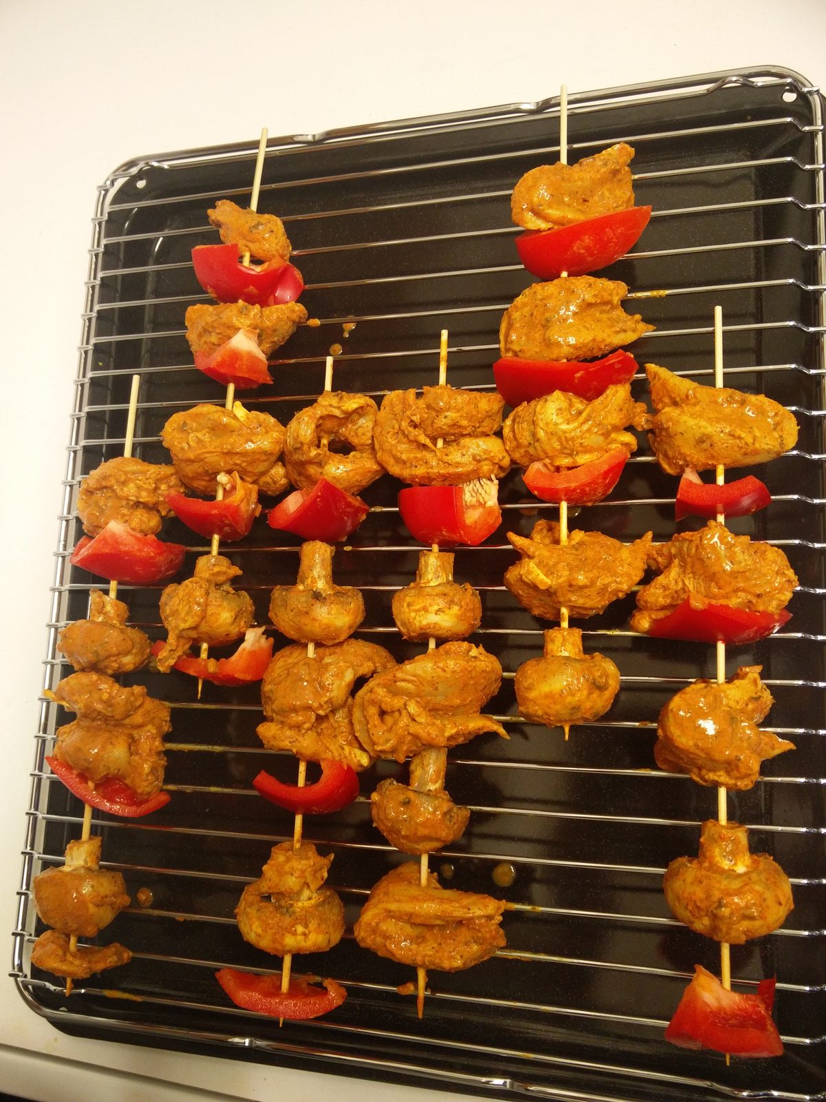 Skewers of tandoori chicken and grilled peppers fresh off the grill